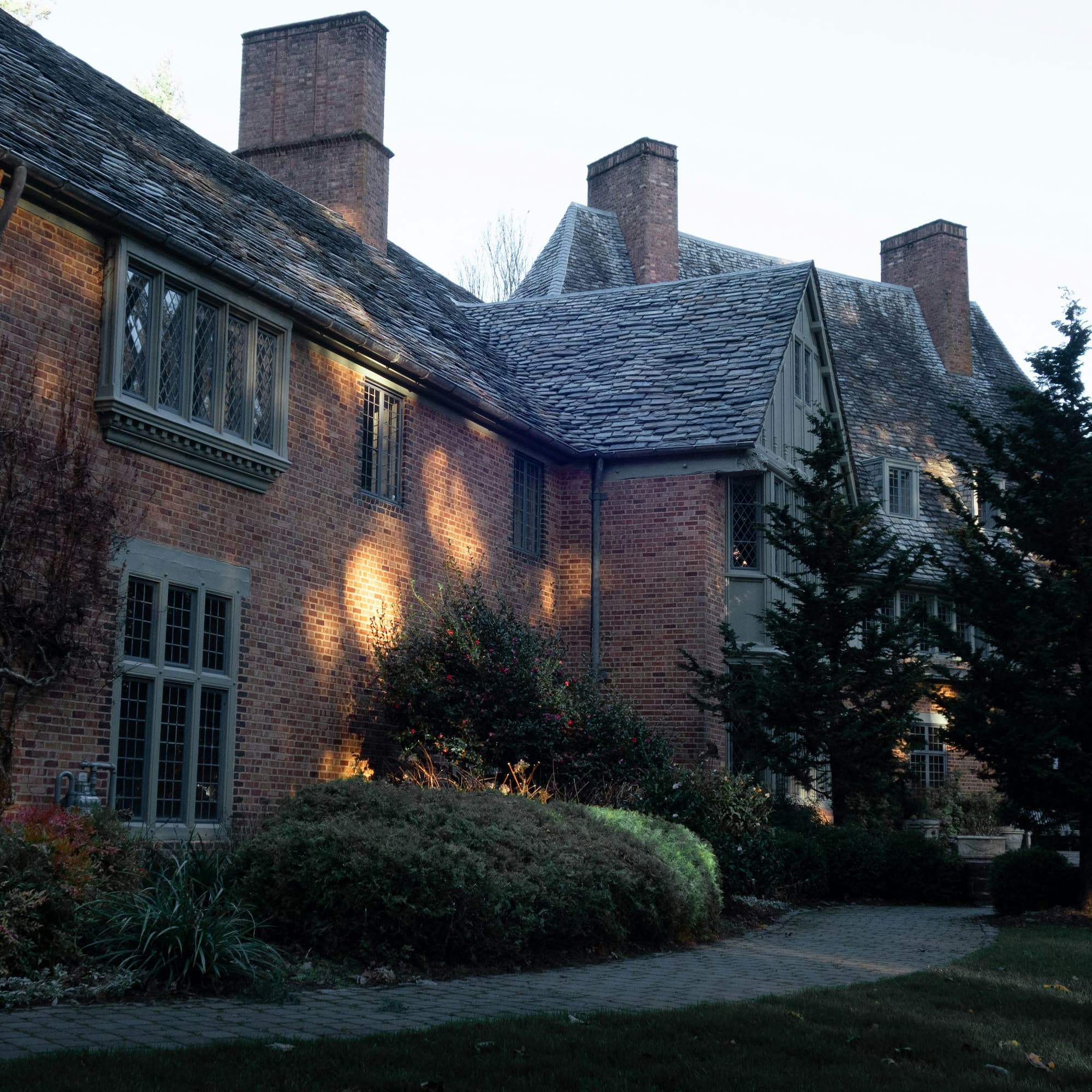 Brick and stone house with tall chimneys and a steep roof