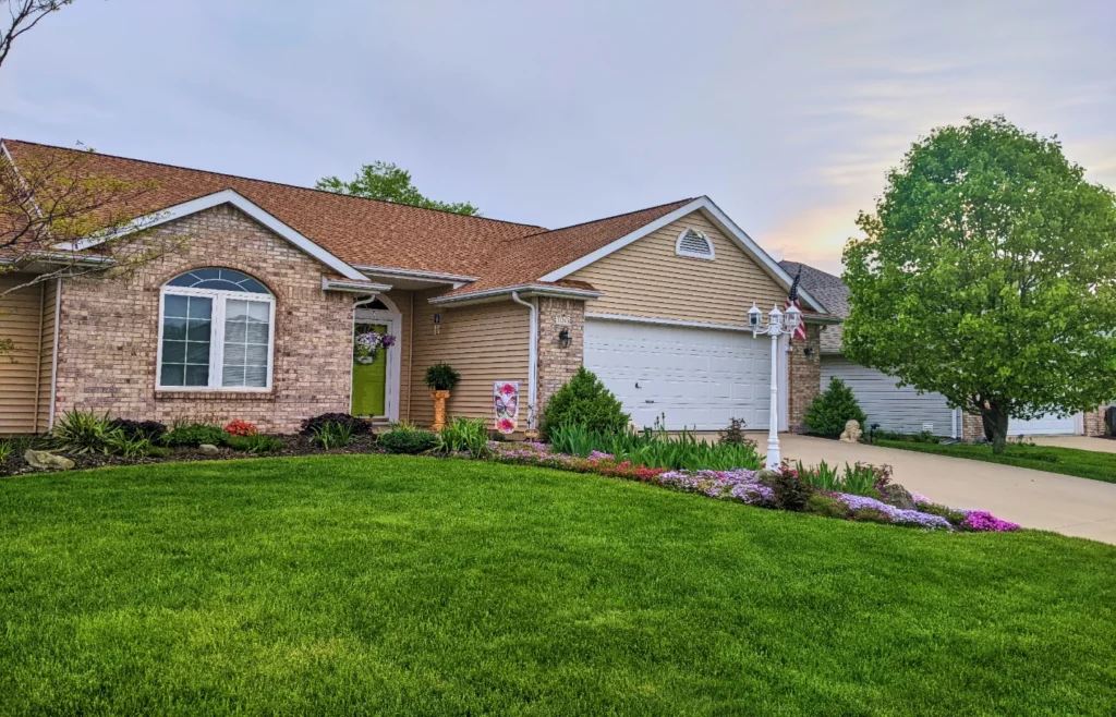A single-story brick ranch home with a landscaped front yard