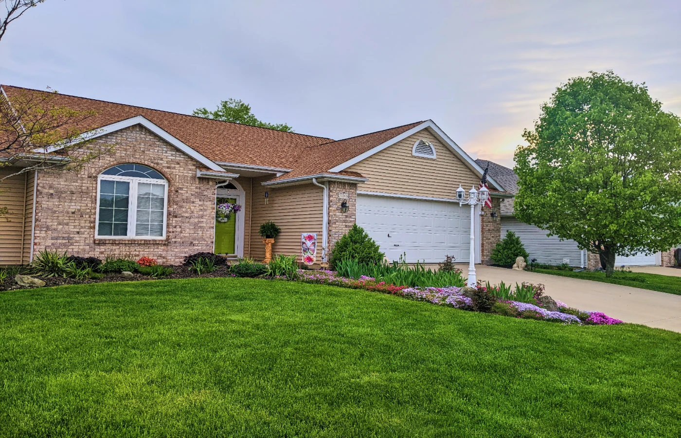 Brick ranch home with an attached garage and a wide lawn