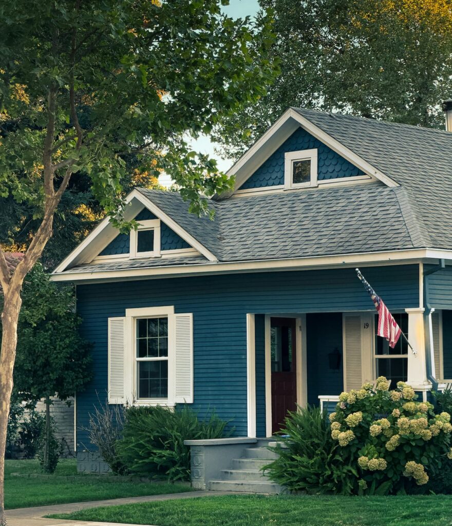 A blue cottage-style home with a front porch